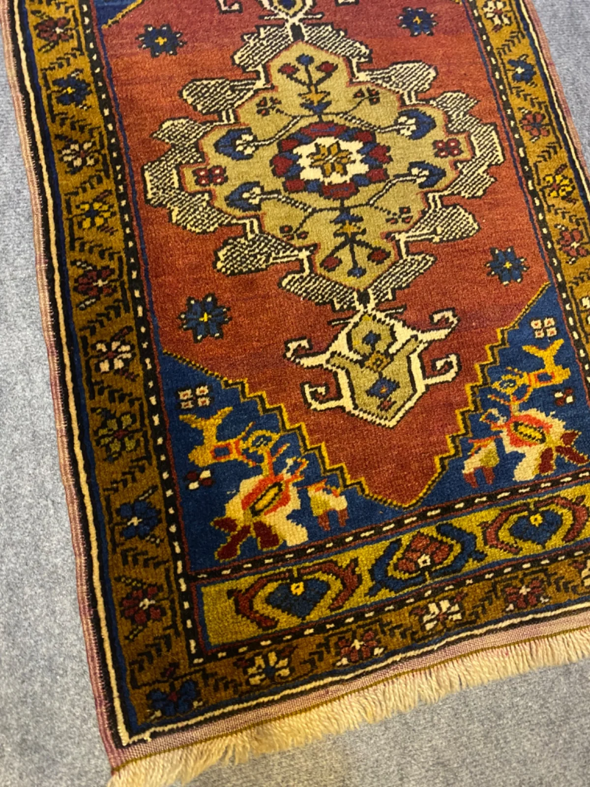 Kiremit zeminli halının fıstık yeşili madalyonu ve lacivert köşeleri