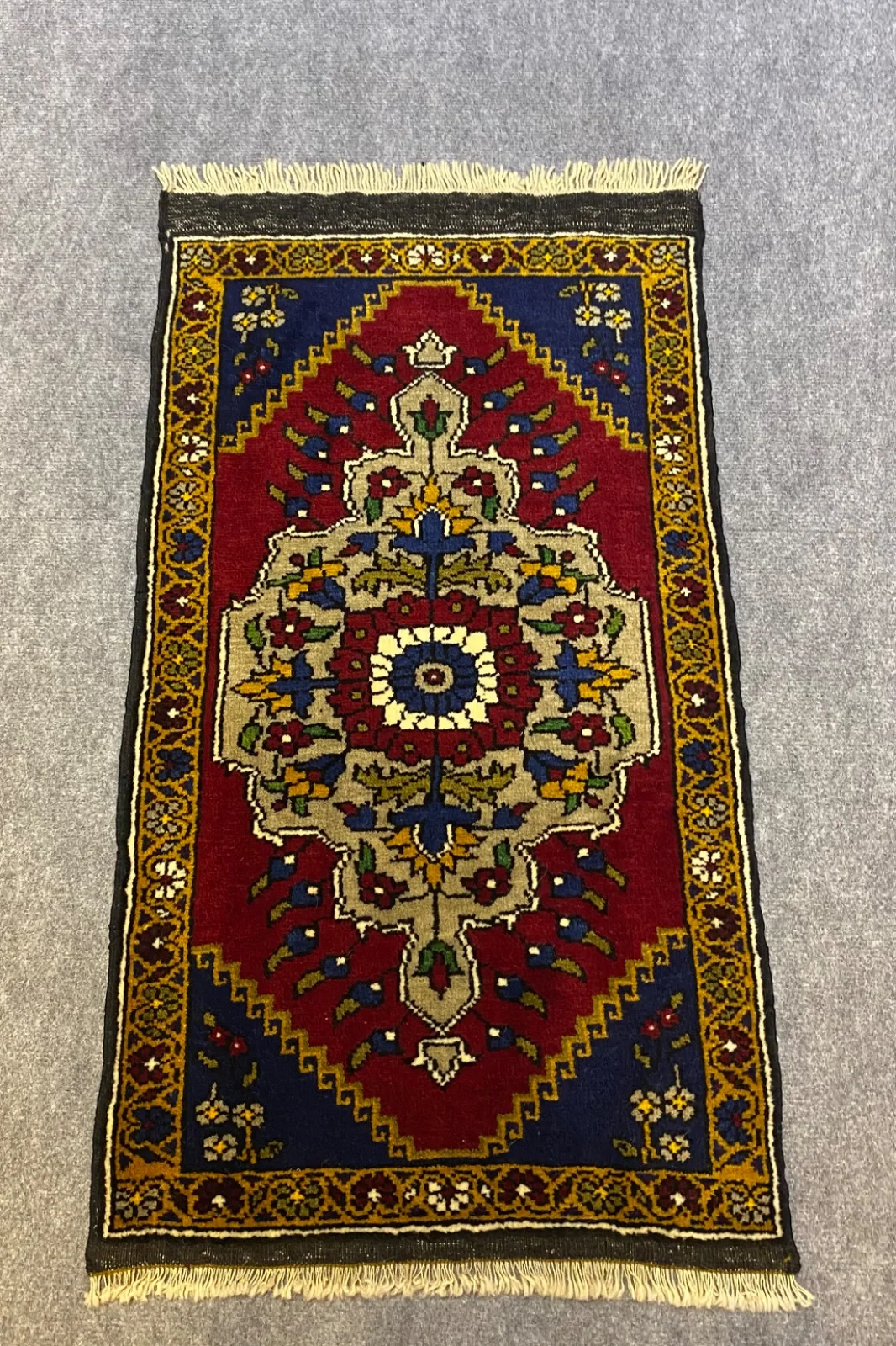 Kırmızı zeminli yolluğun krem madalyonu ve sarı bordürü