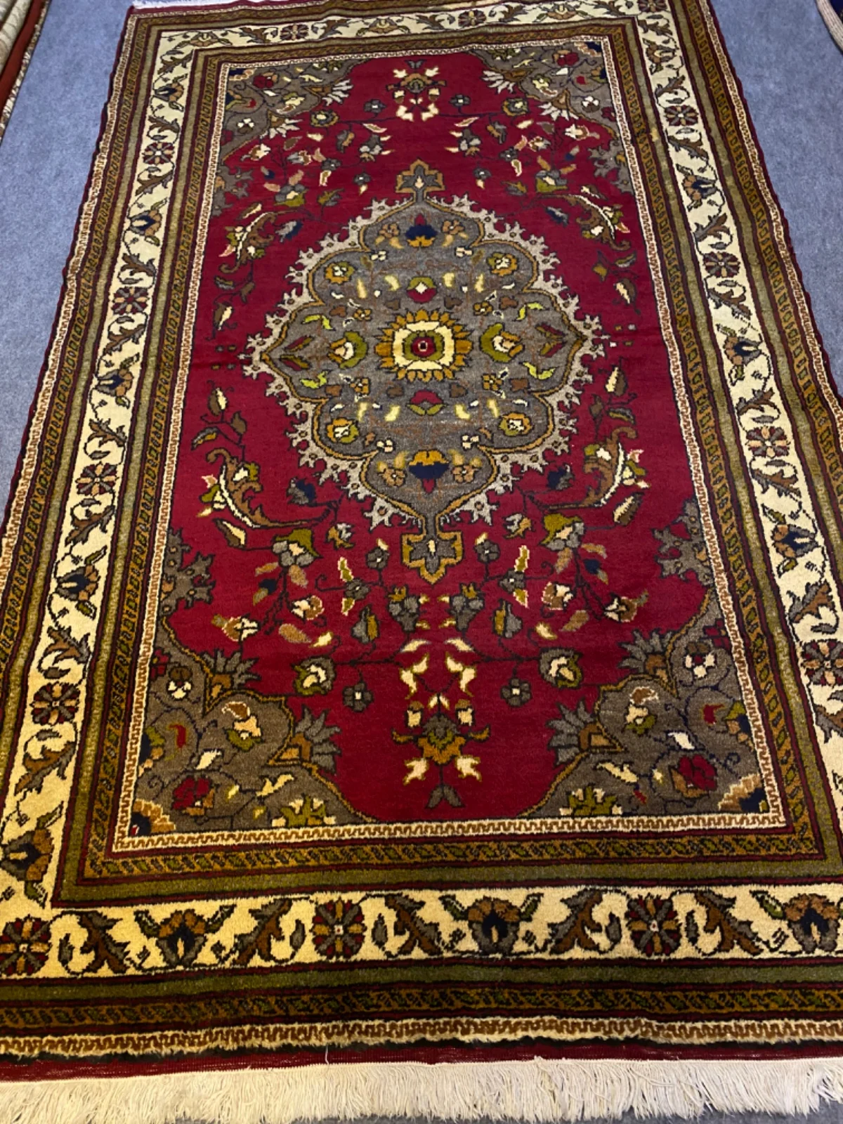 Bordo halının gri-yeşil madalyonu ve çiçek dalları
